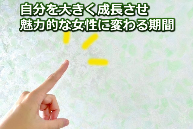 人差し指と「自分を大きく成長させ魅力的な女性に変わる期間」の文字