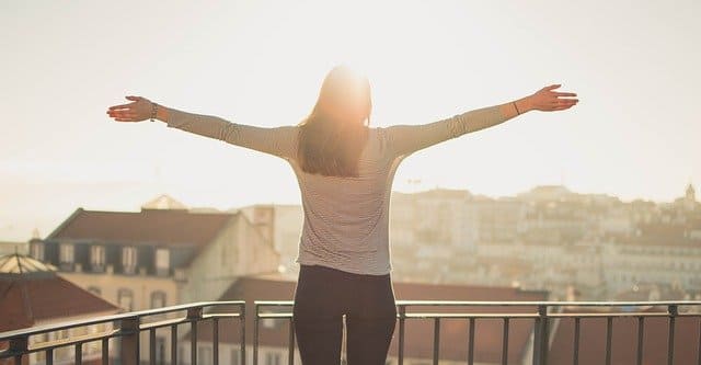 ベランダで太陽の日を浴びる女性